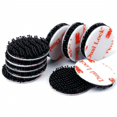 Ten black 3M Dual Lock discs, some stacked and some upright showing the white liner printed with red 3M Dual Lock logos