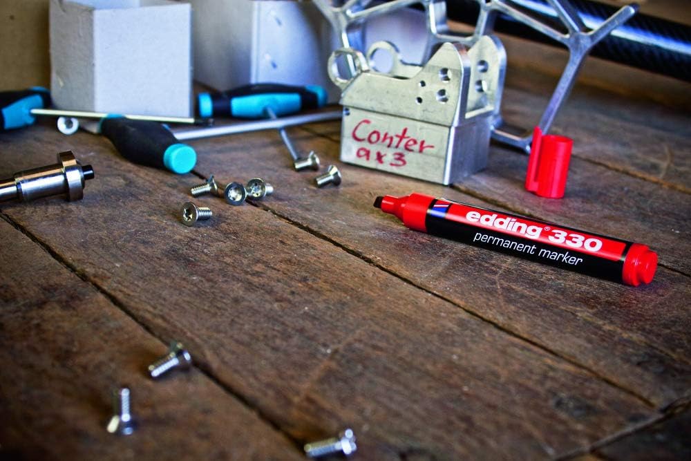 Red Edding 330 (colour shown for illustration) on a workbench beside screws and a box labelled in marker