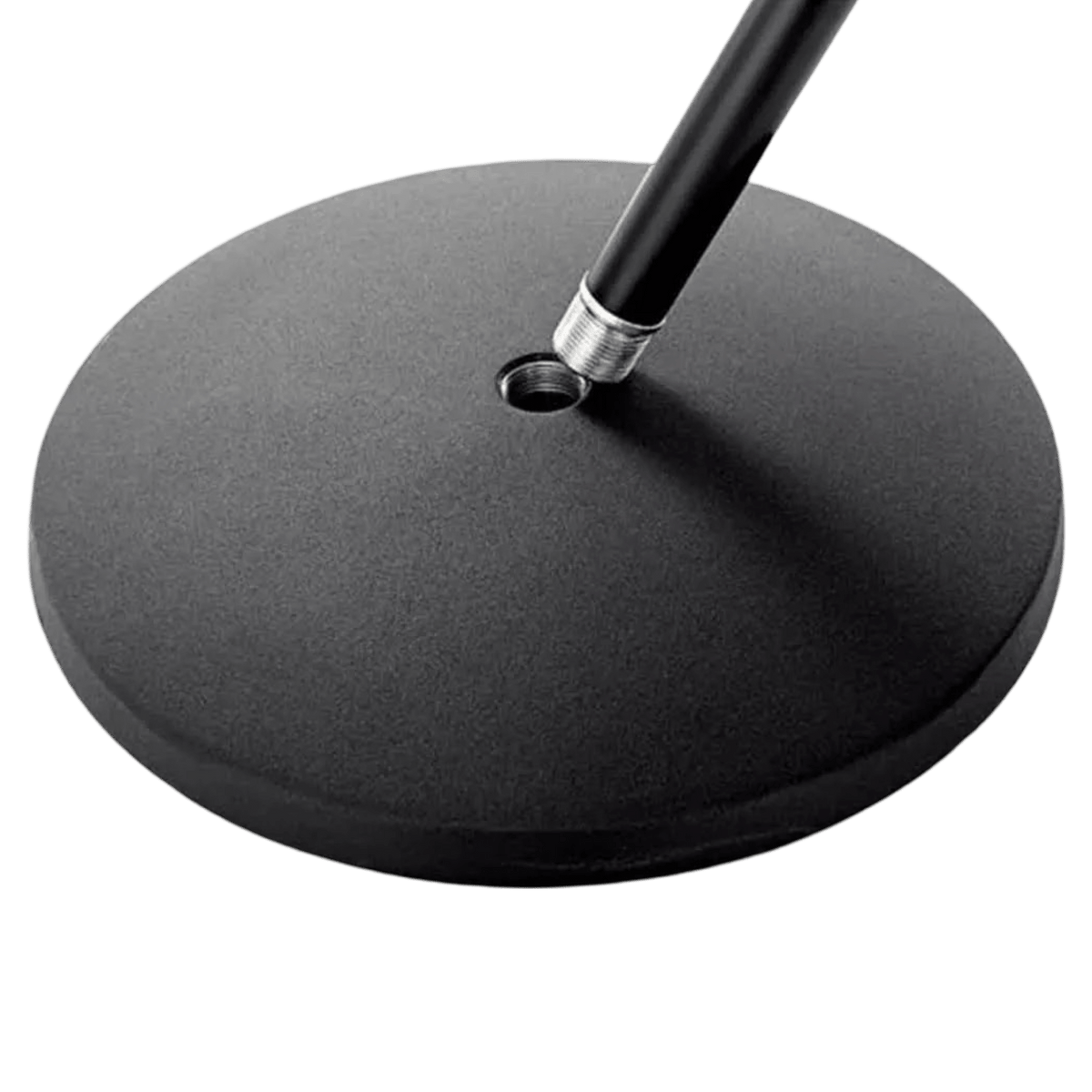 Close-up of the flat black round base of the K&M 26085, with the stand tube and its silver collar at the socket