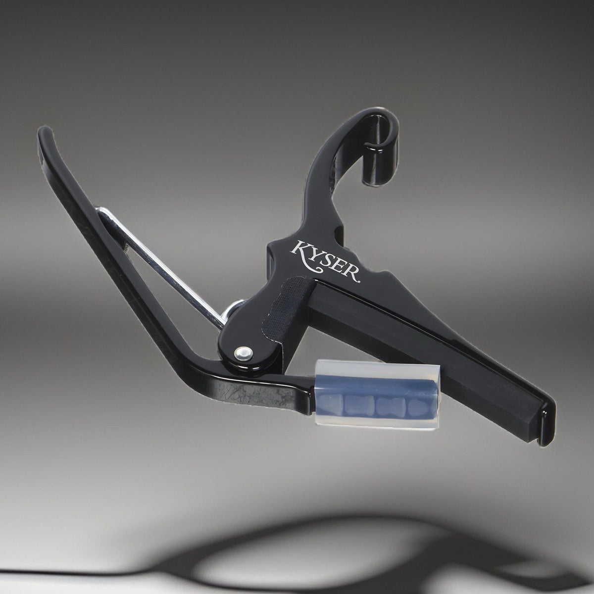 Black Kyser KG6B trigger capo on a grey background, Kyser logo on the side of the body