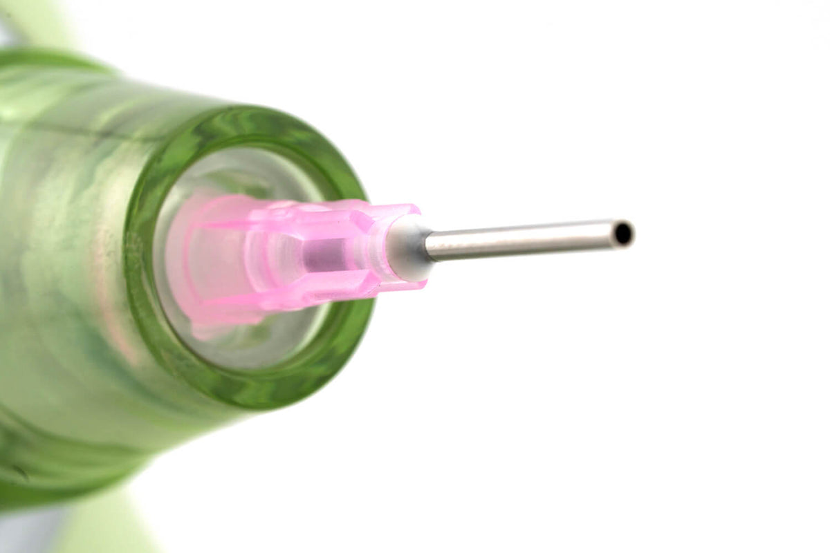 Close-up of the Soundz Vac-Pro pink-hub metal needle tip in its clear green nozzle cone