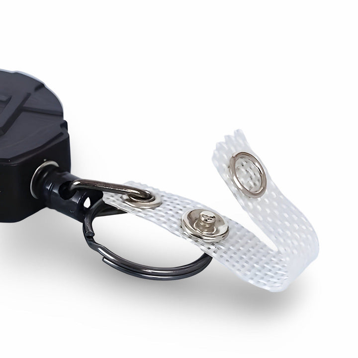 Close-up of the reel's cord end: split key ring and white mesh badge strap with a press-stud fastener
