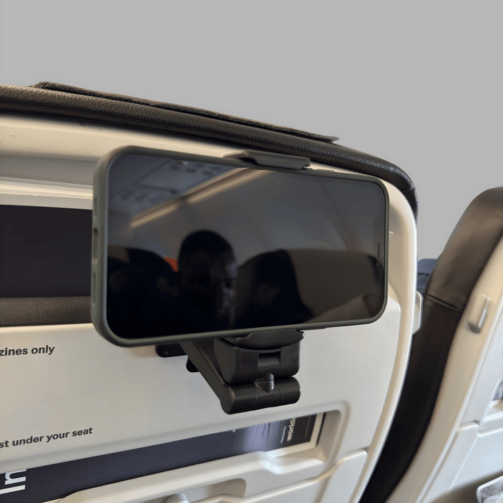 Black clamp phone holder fixed to an aeroplane seat-back, holding a phone in landscape