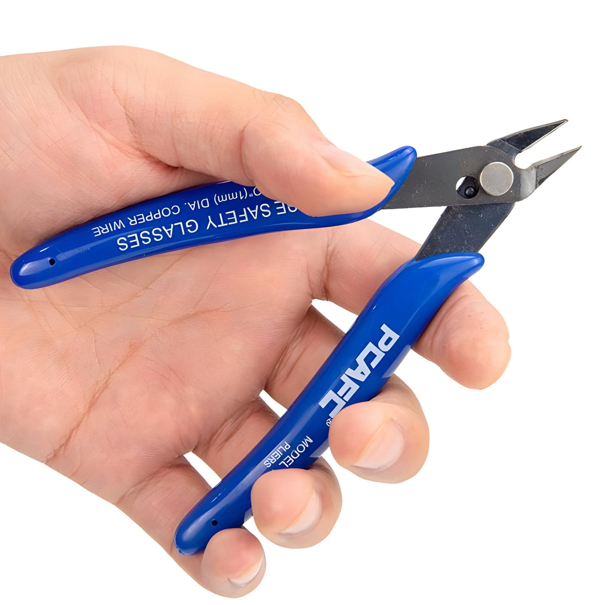 Blue-handled 5 inch side cutters held open in a hand, showing the fine pointed jaws, on a white background