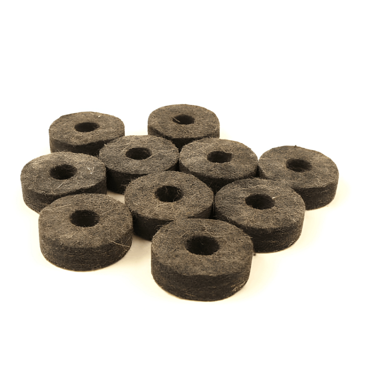 Ten charcoal-black WorldMax felt cymbal washers grouped together, showing their centre holes and thickness